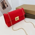Piccola borsa a tracolla rossa trapuntata con catena dorata su tavolo bianco - Rosso