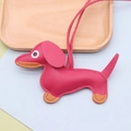 Detail of pink faux leather dachshund pendant with orange stitching and leather lanyard - Dachshund / Rose Red