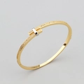 Eleganter Goldarmreif mit Silberakzenten und Zirkonia-besetztem T-Design - Bangle / Gold