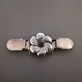 Gros plan sur un clip à pull vintage en forme de fleur argentée avec détails ciselés - Style 13 (Fleur creuse vintage en argent)