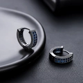 Gros plan de créoles en bronze avec des pierres de zircone cubique bleues - Noir Zircone Bleue