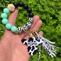 Detail of beaded keychain bracelet with cow print tassel and Mama cow head pendant - Mint Green/Cow Print