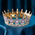 Luxurious golden bridal crown with purple teardrop gemstones on blue silk - Gold Base Violet Rhinestone
