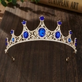 Detailed view of a gold crown with blue oval gemstones and clear crystals on wood - Gold Base Royal Blue Zirconia