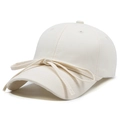 Stylish cream baseball cap with elegant ribbon bow decoration in a 45-degree side view - Beige