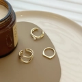 Driedelige gouden geometrische ringenset met parels en golfpatronen op een chic bord - Geometrische Gouden Ringenset / Goud