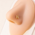 Macro shot of gold letter N nose stud with micro-pave zircons on a realistic model - Letter N / Gold