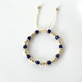 Detailed macro of gold plated beads and blue square crystal bracelet with cord closure - Dark Blue