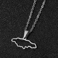 Macro d'un collier pendentif carte de la Jamaïque en acier inoxydable sur fond noir - Acier Creux