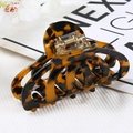 Macro shot of tortoiseshell acetate hair claw clip with hollowed-out pattern and spring - Hollow Claw / Tortoise