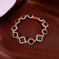 Macro di bracciale dorato con pietre blu scuro e cristalli bianchi su seta marrone - Oro-Blu-Fiore
