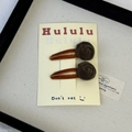 Pair of brown velvet rose hair clips for women displayed on a beige vintage card - Brown