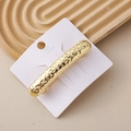 Close-up of a gold rectangle hair clip with unique hammered texture on a white display card - Pleated Arch Barrette Gold