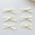 Top view of six white ribbon bow hair clips arranged neatly on a plain grey background - Beige (6 Pack)