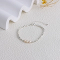Detail of silver geometric beaded bracelet with three freshwater pearls on white textured background - 3 Pearls Silver Bead Bracelet