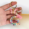 Detailed shot of resin 'G' letter keychain with heart sequins, pink butterfly and tassel - Butterfly Tassel 8-Shape Buckle / Letter G