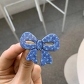 Detailed close-up of blue polka dot denim bow hair clip with golden metal duckbill clamp - Bow / Denim Blue Bow