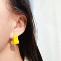 Primo piano dell'orecchino a cerchio irregolare in smalto giallo indossato dalla modella - Stile a Forma di C Torto Irregolare / Giallo