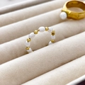 Detailed macro view of beaded freshwater pearl and gold ring on a velvet jewelry case - US 6 / Alternating Freshwater Pearl and Round Beads
