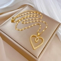 Close-up of golden double heart pendant with white crystals on champagne jewelry box - Heart-Shaped Clavicle Chain / Gold