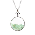 Detailed close-up of a round silver pendant filled with natural green tumbled stones - Silver+Aventurine