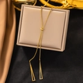 Detail of adjustable slider clasp and gold geometric triangle pendants on velvet box - Triangle Tassel / Gold