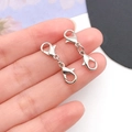 Macro shot of silver double-ended lobster clasps for DIY jewelry necklace making - White K/Silver