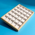 Wooden 24-compartment jewelry display tray with white lining on blue background - 30-Grid Tray