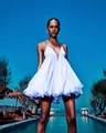White halter neck backless dress with tiered ruffle hem in a breezy outdoor pool setting - White 2