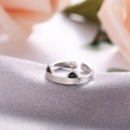 Macro shot of silver adjustable cat ear ring with black enamel on grey silk fabric - Black Cat Ears