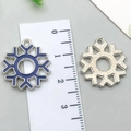 Blue enamel and silver alloy snowflake pendant charms shown with a measuring ruler - Dark Blue Snowflake 18x20mm
