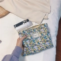 Macro detail of floral cotton cosmetic bag featuring zipper closure and fabric label tag - Black with Blue and Purple Daisy