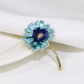 Elegant gold-tone flower brooch with sky blue enamel petals and sparkling center detail - Blue Gradient Daisy