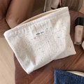 Vista piatta della borsa da trucco retrò in tela crema con trame di fibre colorate - Beige