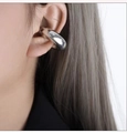 Minimalist silver-toned C-shaped chunky ear cuff with a polished mirror finish on model - Clip-on Earrings / Steel