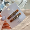 Detail of amber heart hair clips with grey rhinestones on an elegant jewelry display card - Heart Style Brown Pair