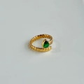 Detailed view of green pear-shaped zircon on golden spiral textured titanium steel ring - Adjustable Size / Green