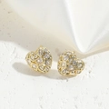 Macro detail of heart-shaped gold earrings with multi-cut sparkling cubic zirconia stones - Heart Zircon Style