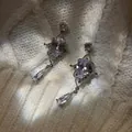 Macro shot of silver teardrop zircon earrings with vintage lace texture on knit background - Silver Needle Waterdrop Zircon Style