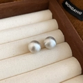 Close-up of silver round stud earrings with a brushed matte texture on velvet display - 12mm / Silver