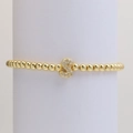 Close-up of golden beaded stretch bracelet with a micro-paved zircon letter S pendant - S