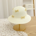 Close-up of beige woven straw hat with yellow lace bows on a gold metal display stand - Off-white Hat