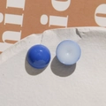 Macro shot of blue and pale blue resin heart cabochons on a white textured ceramic plate - Royal Blue Round