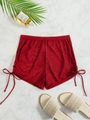 Detail of red mesh beach shorts featuring adjustable side drawstring ties and sheer texture - Burgundy