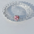 Gros plan détaillé d'une bague coeur en argent avec pierre rose et serti de diamants - Rose