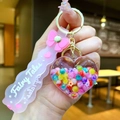 Macro detail of heart liquid keychain with colorful beads and pink Fairy Tales strap - Bow With Iridescent Glow-in-the-dark Bubble Beads And Heart Shape