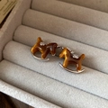 Macro view of brown enamel rocking horse earrings in a velvet gray jewelry box - 51# Brown Enamel Silver Trim Rocking Horse Studs (Pair)