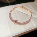 Close-up of elegant rose gold tennis bracelet with shimmering pink zircon stones - Pink