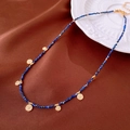 Flat lay of vintage beaded necklace with blue pearls and a gold textured pendant - 29# Necklace - Gold Blue Textured Disc