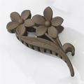 Detail der matten dunkelbraunen Haarklammer mit doppeltem Blumendesign auf weißem Hintergrund - Dunkelkaffee